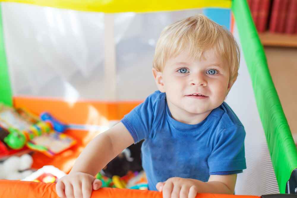 Lindo bebezinho brincando no cercadinho colorido